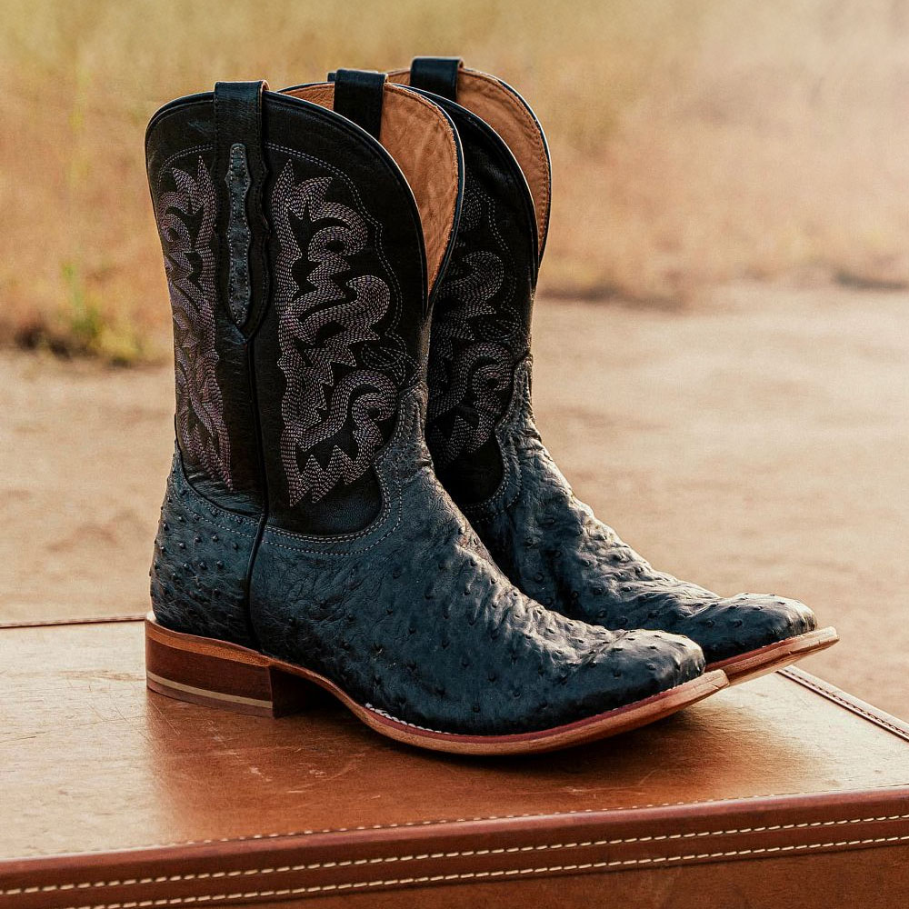 A pair of the Moore 11" Full Quill in Grey sitting on a leather suitcase.